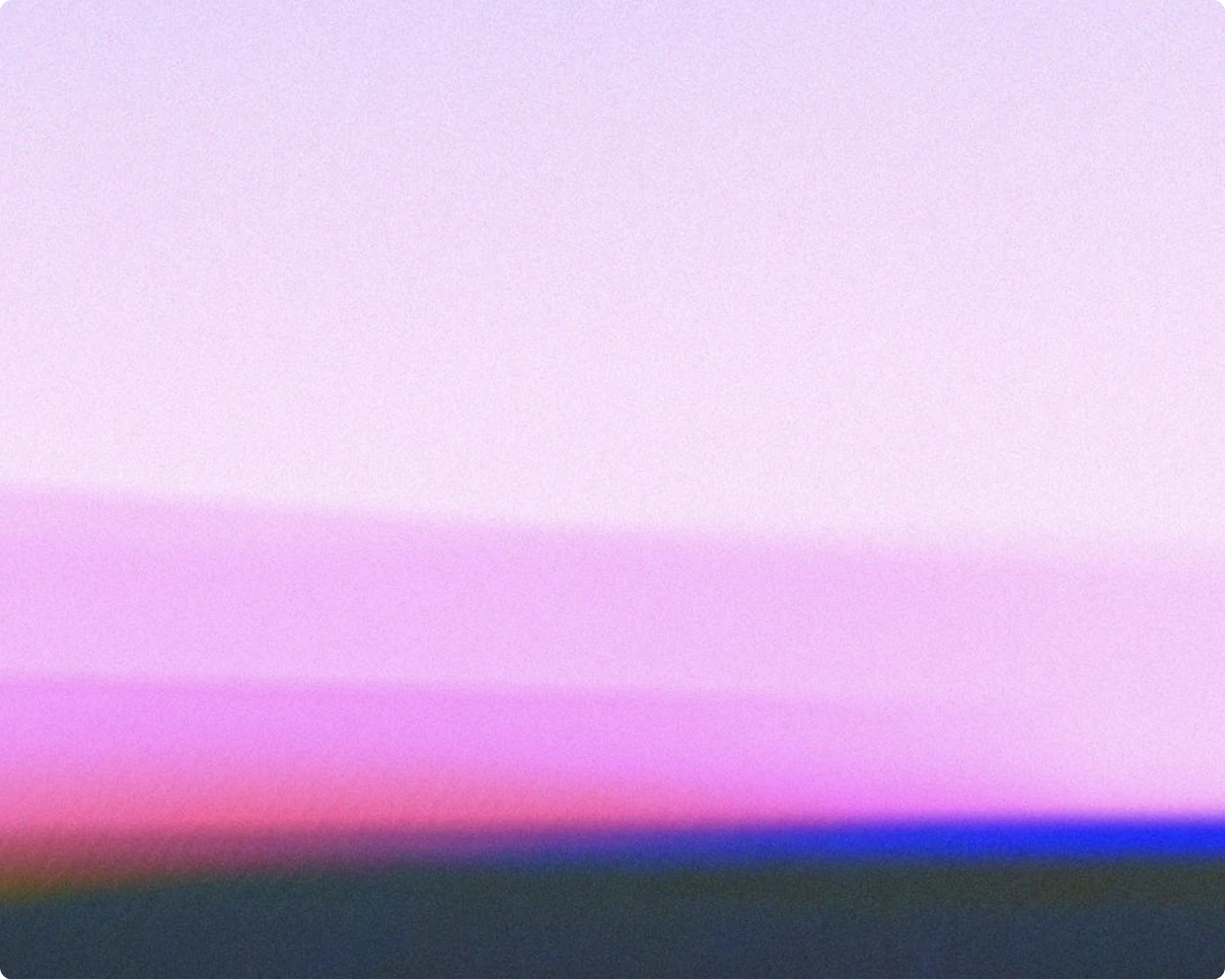 Abstract, grainy gradient image with no distinct objects. Soft pastel colors blend horizontally, transitioning from pale lavender and light pink at the top to brighter pinks and purples in the middle, and fading into deeper blue and dark gray tones near the bottom, evoking a hazy sunset or atmospheric horizon.
