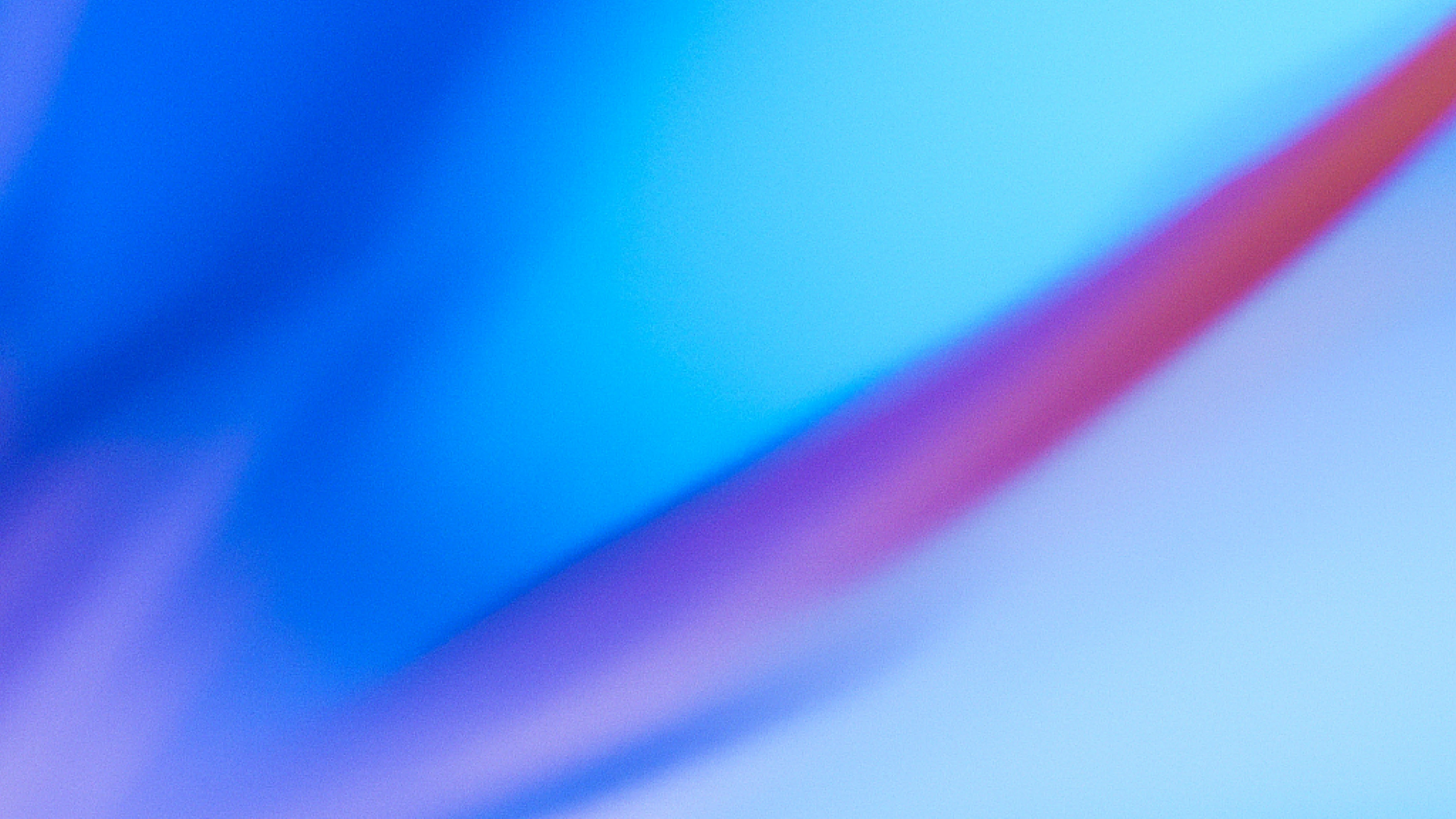 Abstract background with blended gradients of deep blue, light blue, purple, and a streak of red, creating a smooth, dynamic diagonal flow.