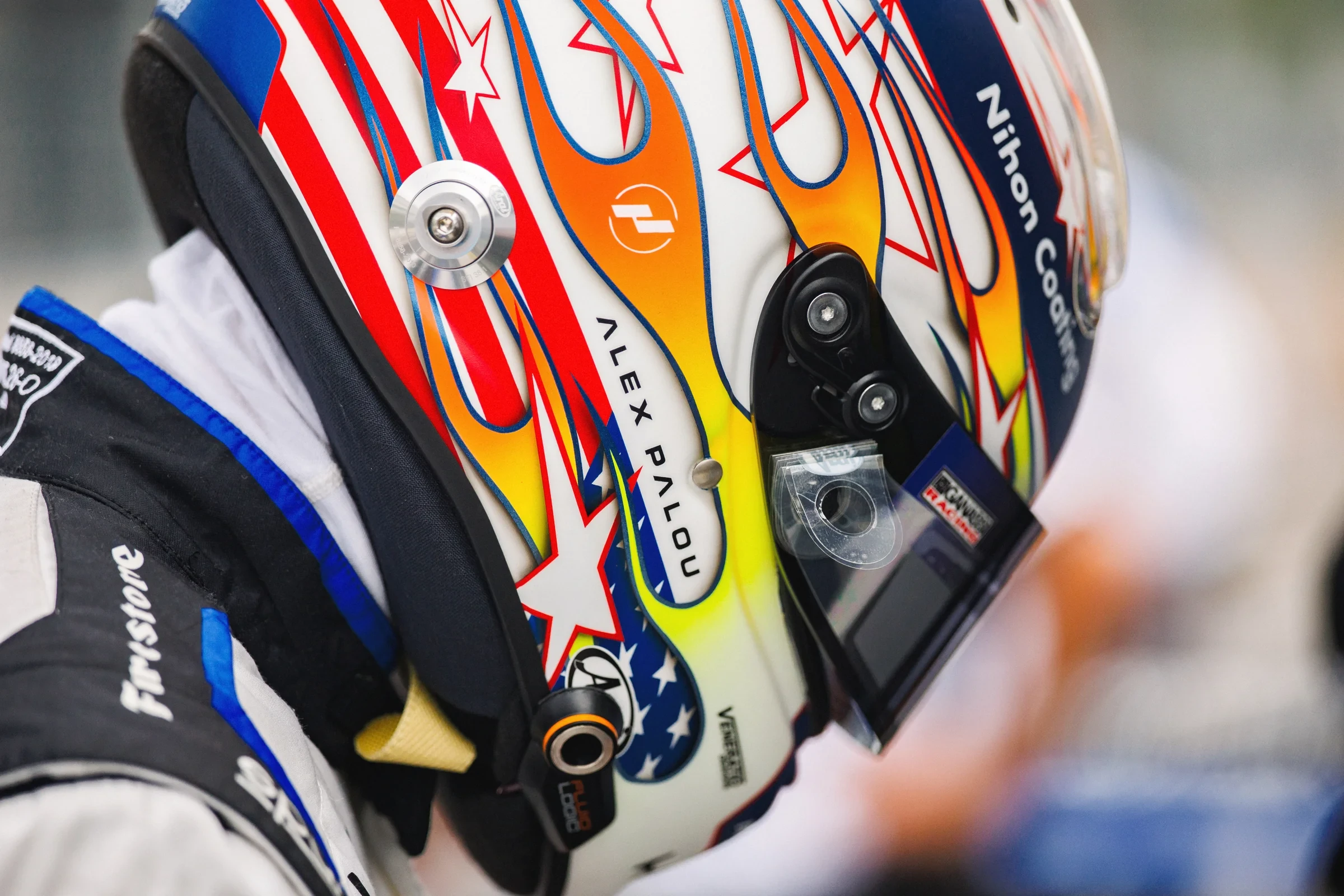 Close-up of a colorful racing helmet beside a racing suit.
