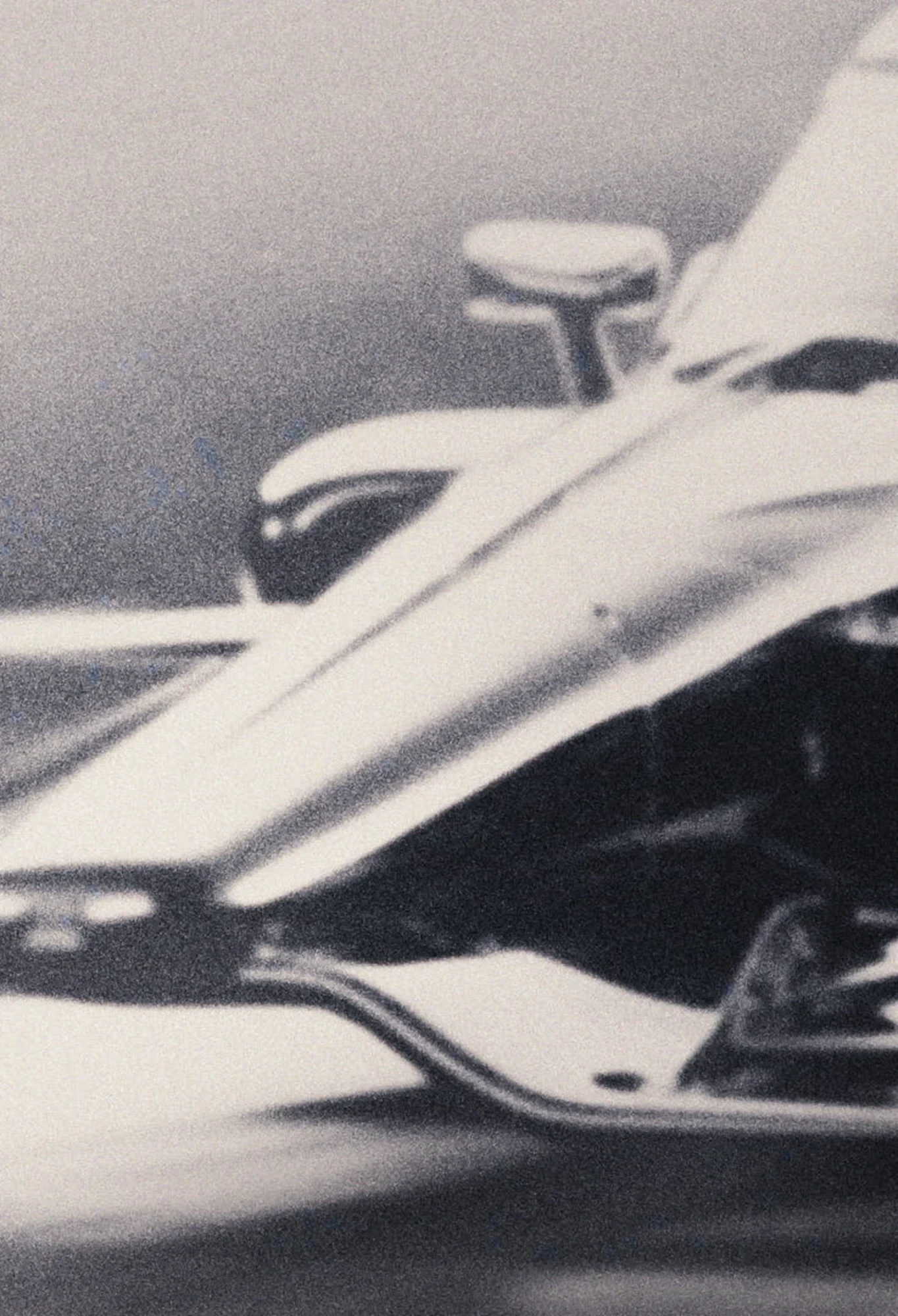 Monochrome close-up of an IndyCar’s front wheel and bodywork.