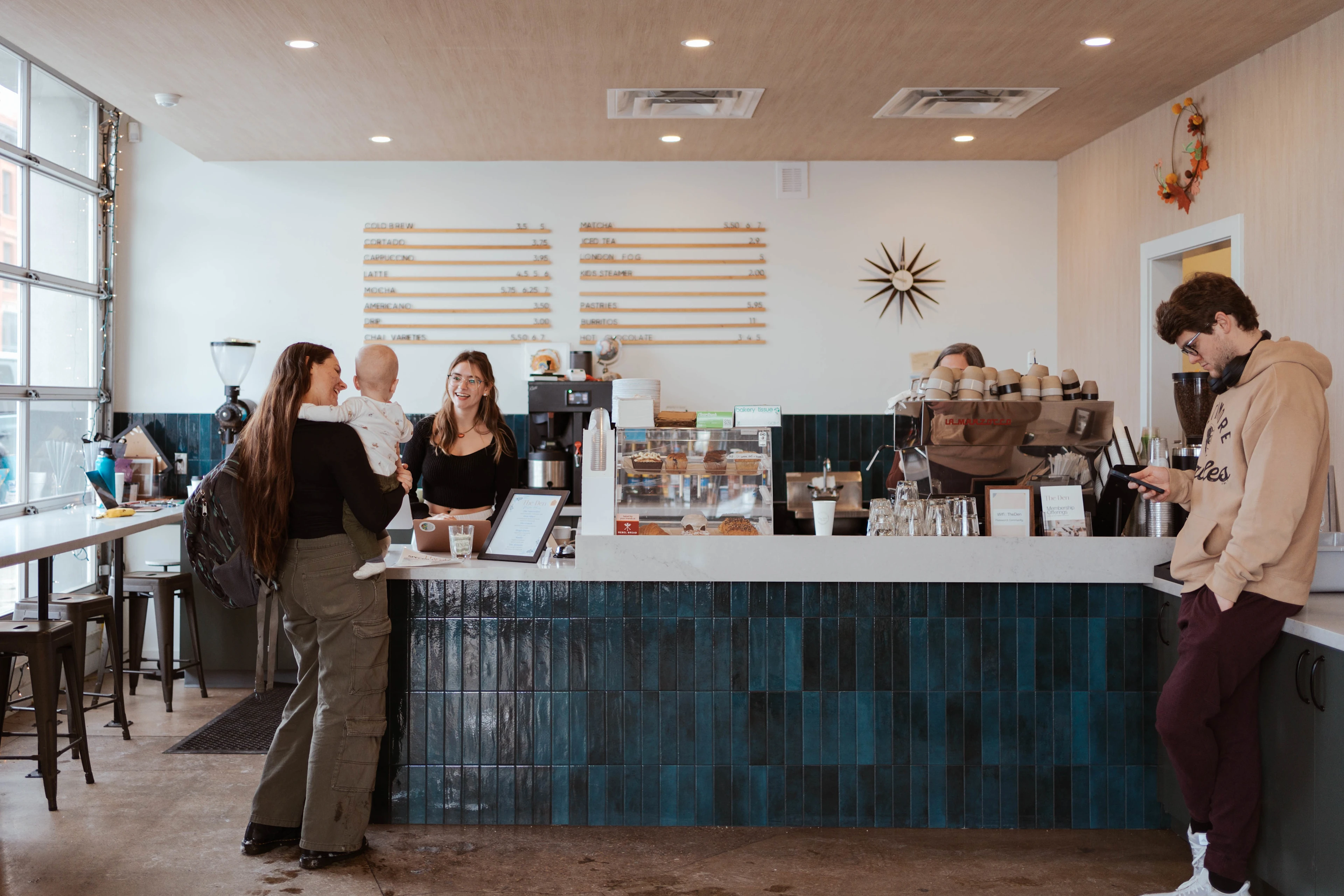 Visitors and staff at the coffee counter inside The Den Family Social.