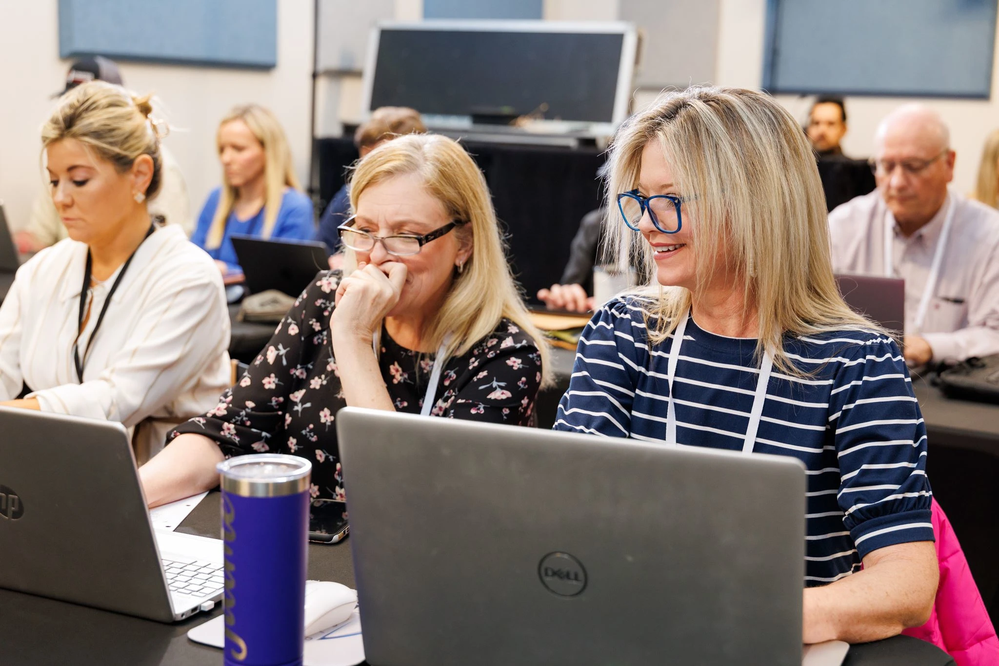 Participants use laptops during an OpenAI Academy training session.