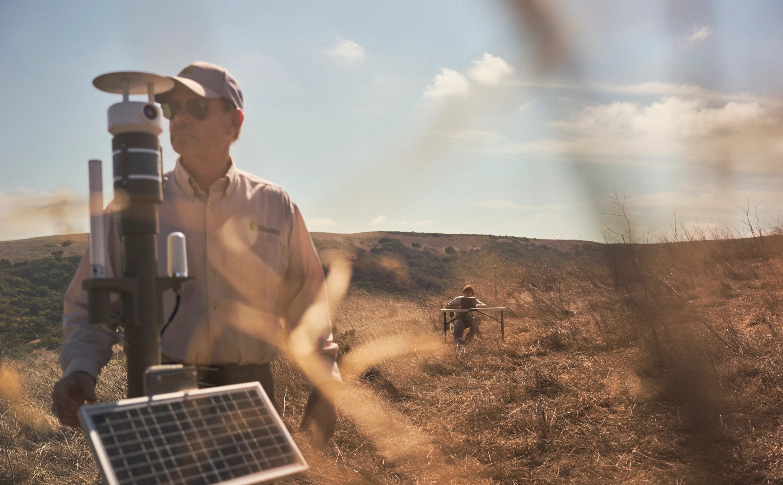 Ryan deploys wildfire sensor equipment in dry terrain.