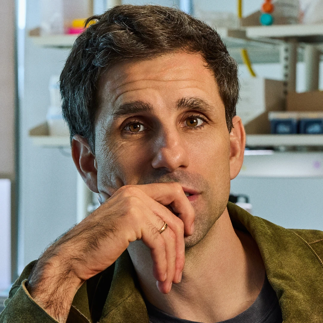 Dr. César de la Fuente in profile against a colorful lab display.