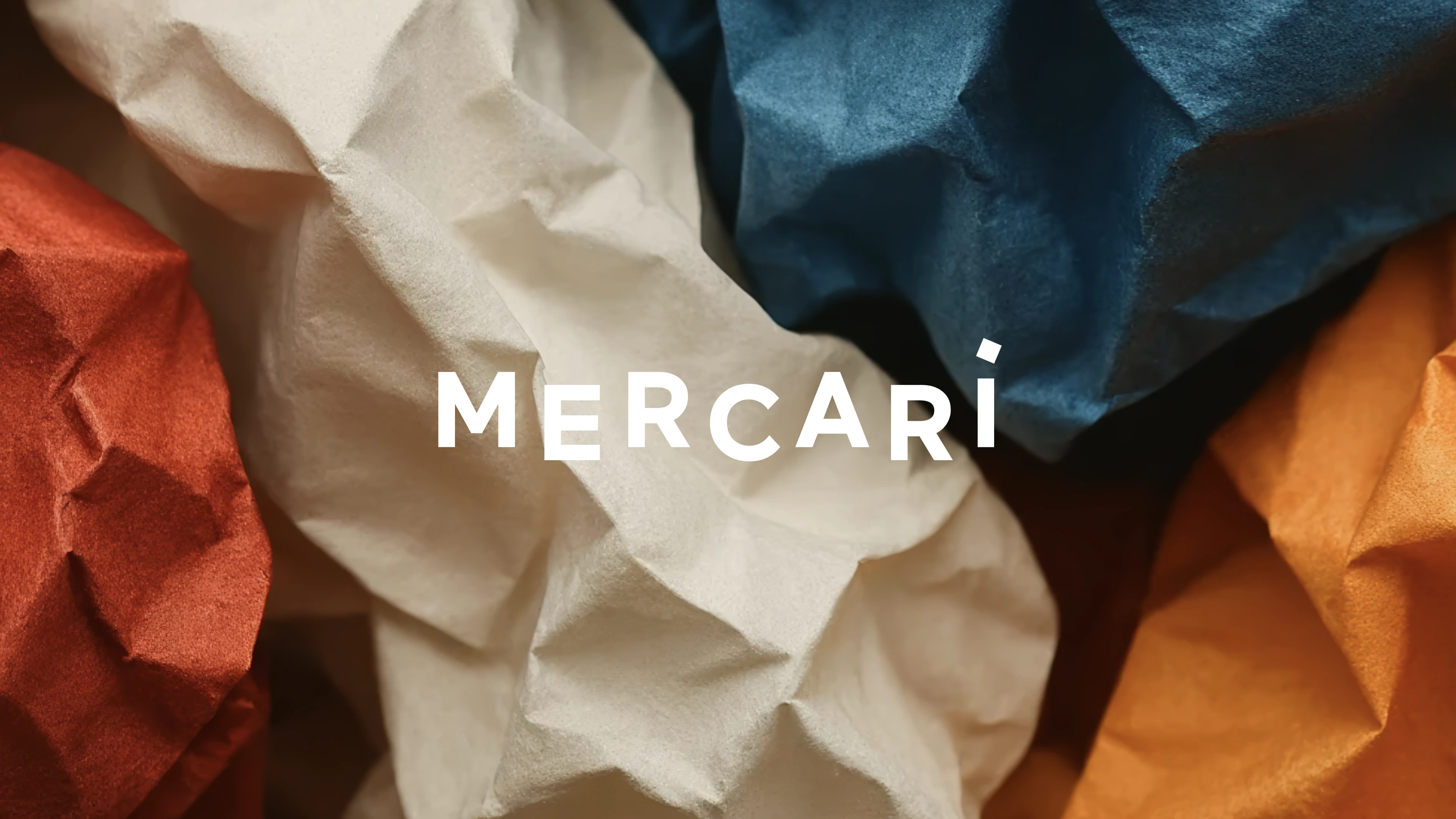 Mercari logo over a background of three bold, colorful 3D blocks in red, blue, and yellow, creating a dynamic and modern design.