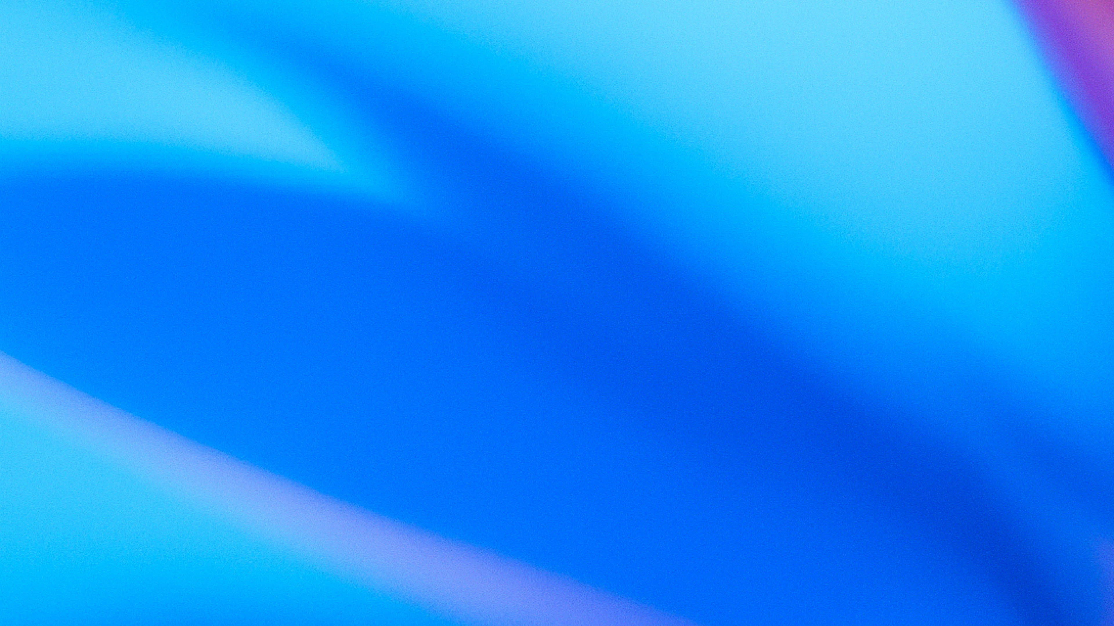 Abstract image with rich gradients of deep blue and cyan, accented by soft streaks of purple and pink, creating a dynamic flowing composition.