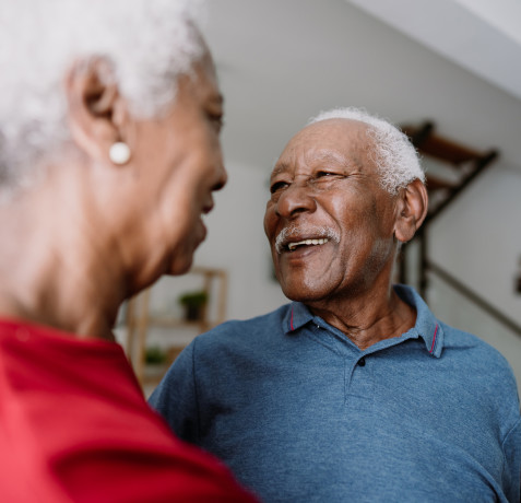 Elderly man is smiling at his relative caregiver