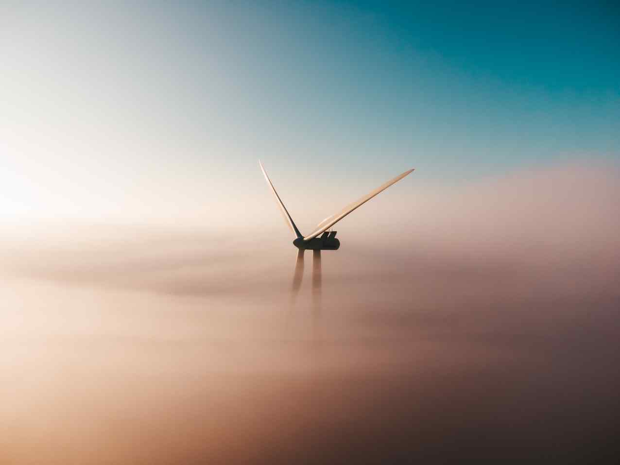 A windmill rising above the clouds.
