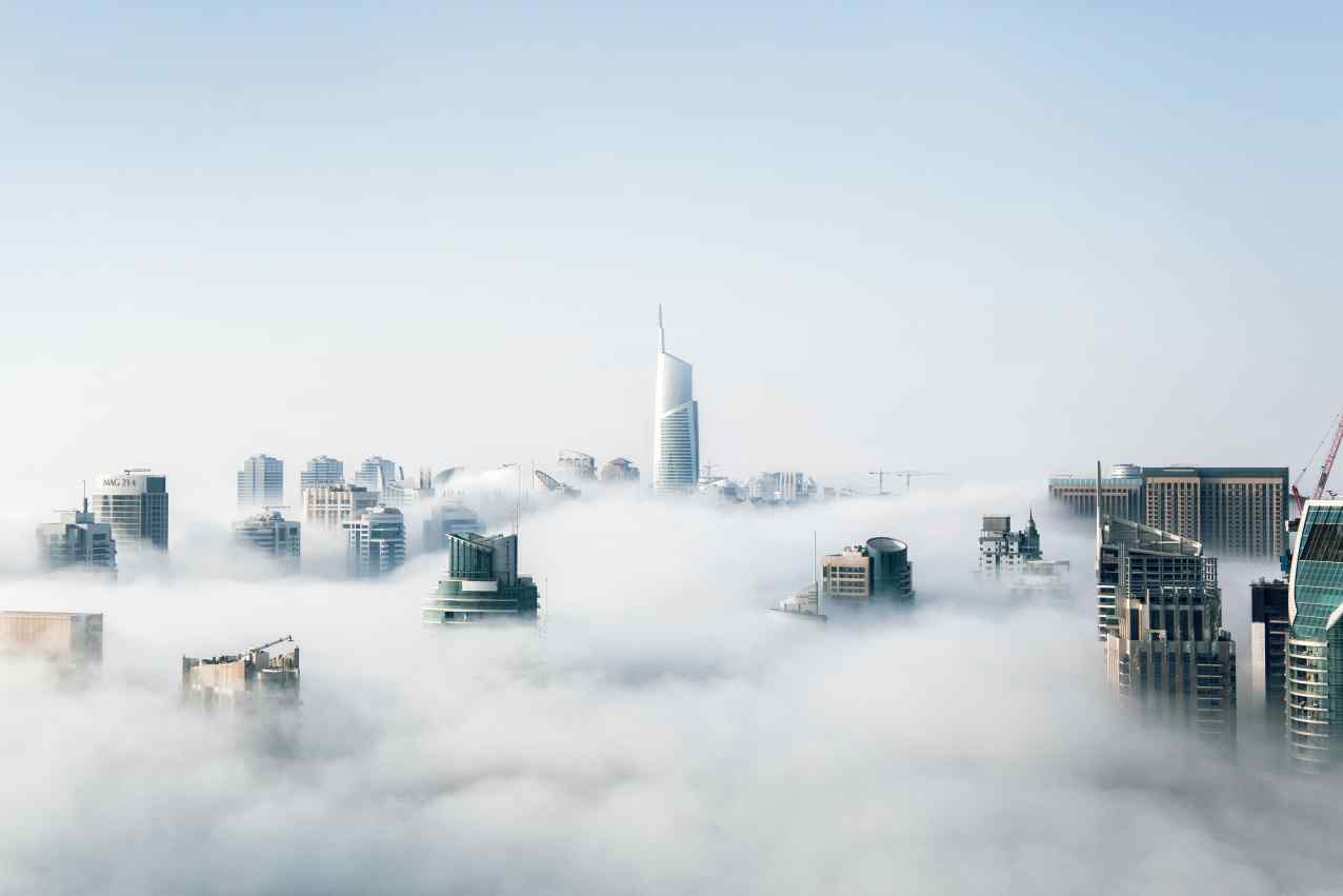 Skyscrapers rising above the clouds.