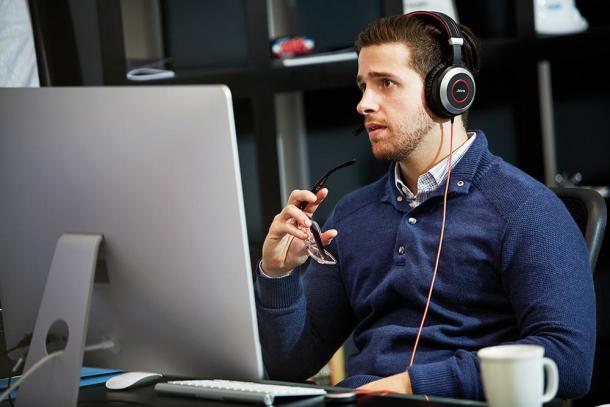 Mann mit Jabra-Kopfhörern am Computer