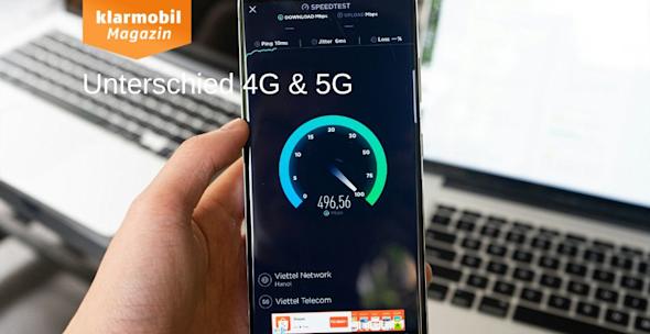 mic: Unterschied 4G und 5G_Headerbild Person hält Handy, auf dem Speedtest durchgeführt wird in der Hand, im Hintergrund verschwommen zwei Laptops