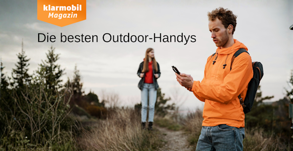 Headerbild Beste Outdoor Handys 2025, Mann mit orangener Jacke steht im Vordergrund und hält ein Handy in der Hand, im Hintergrund steht eine Frau, beide sind in der freien Natur