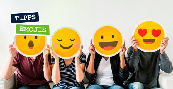 Vier Menschen, die sich vier verschiedene Emojis aus Papier vor Ihre Gesichter halten.