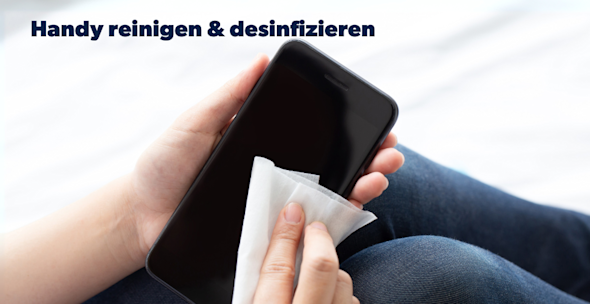 Ein Handy wird mit einem Reinigungstuch gesäubert