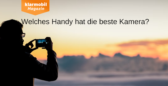 Umriss einer Person, die verschneite Landschaft kurz vor Sonnenuntergang fotografiert