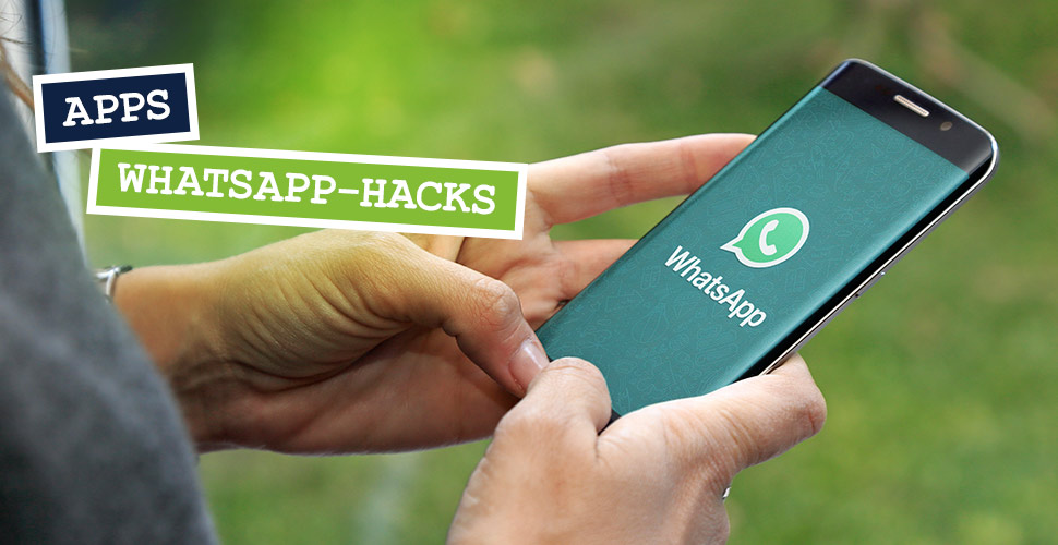 Eine Frau hält ein Smartphone, auf dessen Display WhatsApp zu sehen ist.