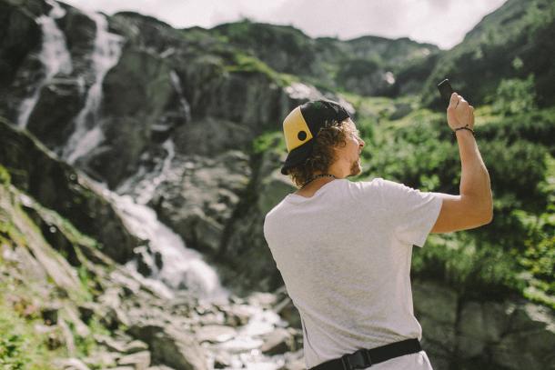 Bestes Outdoor-Handy: Wanderer macht Foto von Wasserfall