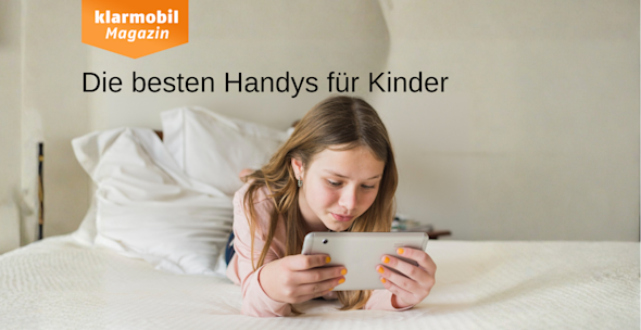 mic: Bestenliste Kinderhandys_Headerbild Mädchen liegt mit Handy in der Hand auf einem Bett