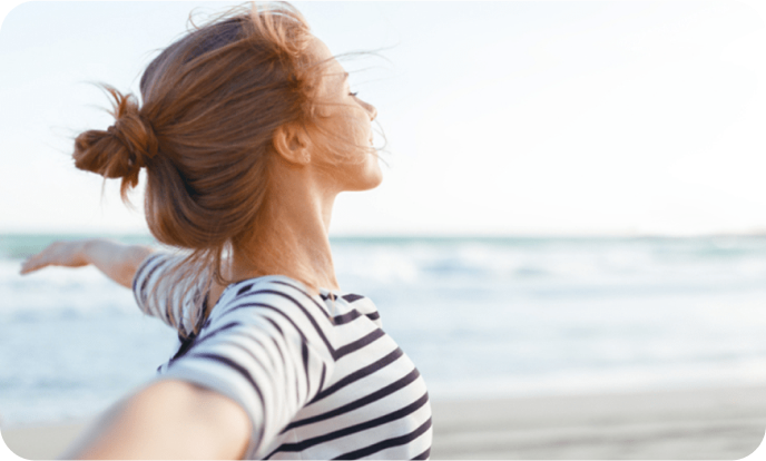 Jeune femme embrassant la liberté au bord de la mer