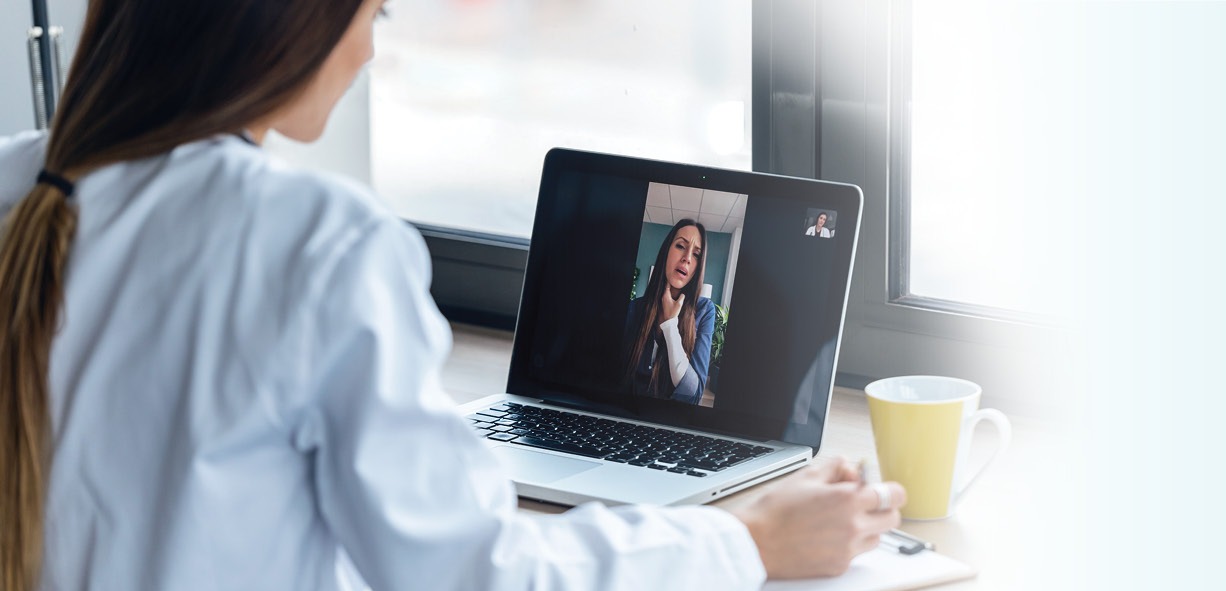 Woman in white coat watching a webinar