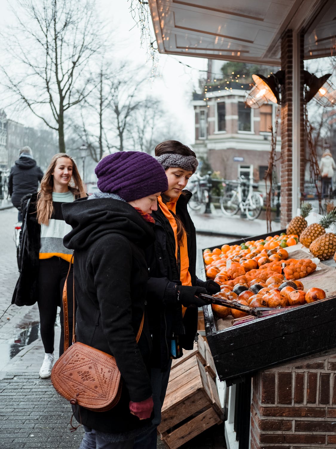 vrouwen-op-markt-in-de-winter-oranje-stad-muts-winterjas-prima-chick-op-achtergrond
