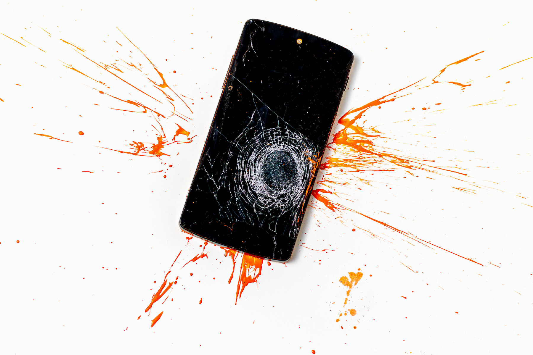 Mobiel met gebroken scherm en oranje spetters