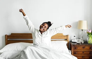 Woman stretching in bed after restful sleep 