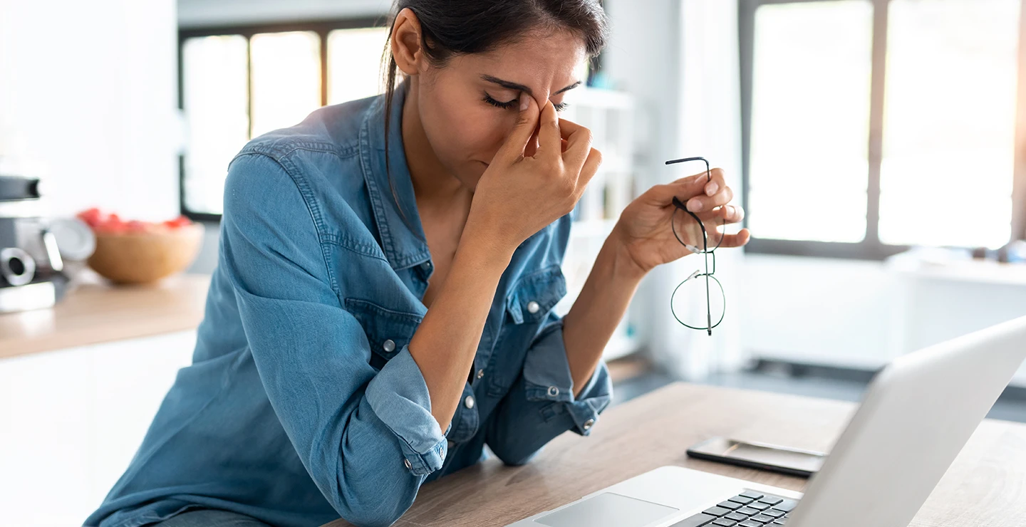 Woman rubbing her eyes struggling to focus because of lack of sleep 