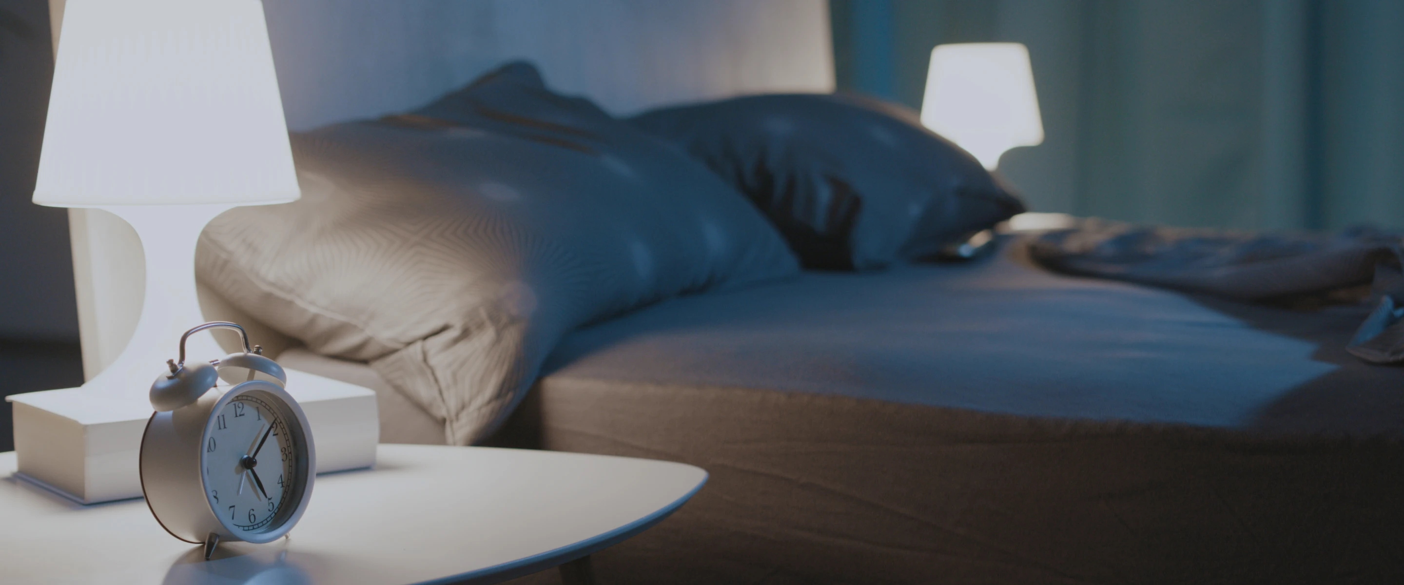 a picture of a bed with alarm clock