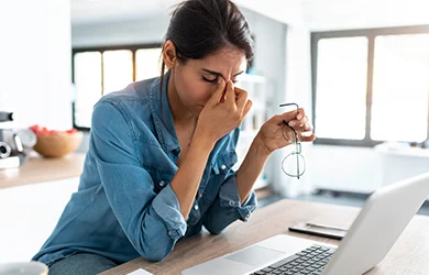 Woman rubbing her eyes struggling to focus because of lack of sleep 