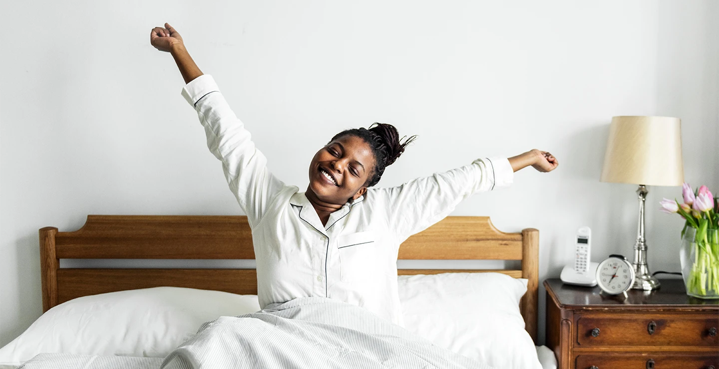 Woman stretching in bed after restful sleep 