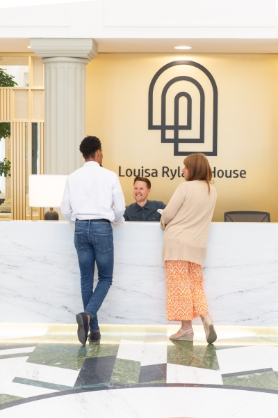 View of two members of public in reception of Louisa Ryland House asking receptionist a question