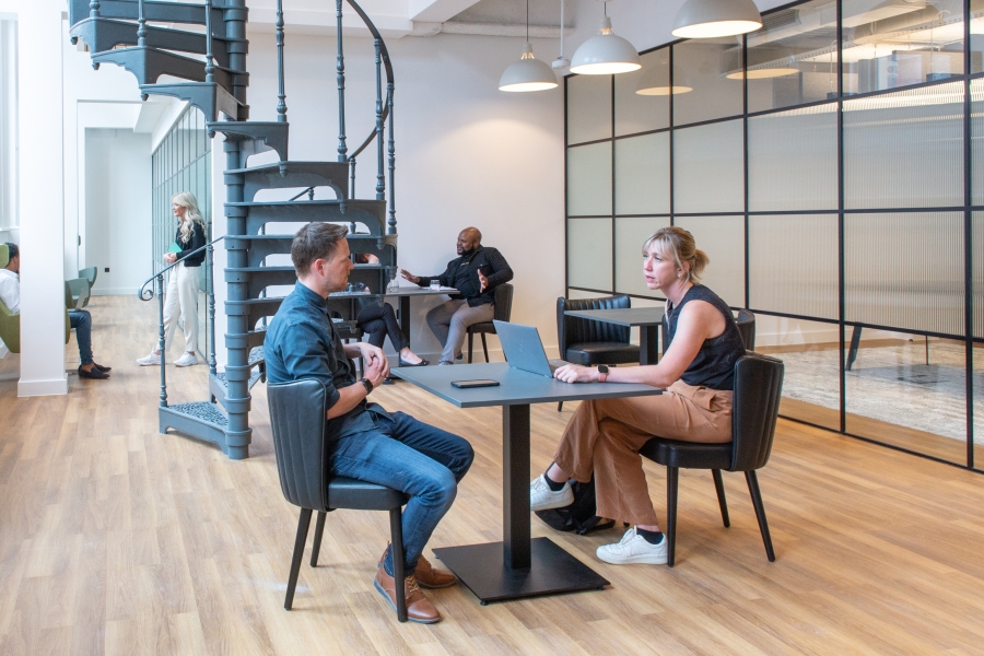 View of touch-down meeting in breakout area of Louisa Ryland House with internal spiral staircase and meeting room in background