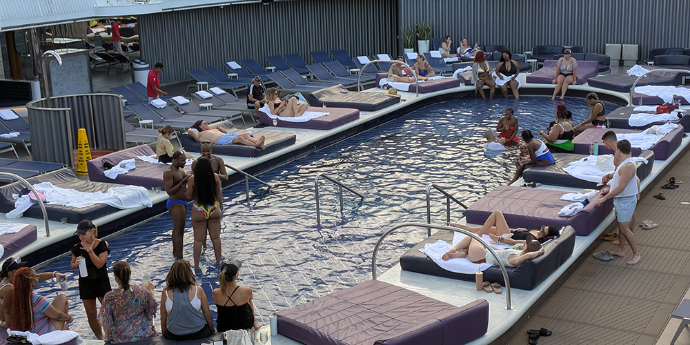 The main pool on Virgin Voyages, with luxurious pool-side double-wide loungers perfect for soaking in some sun.
