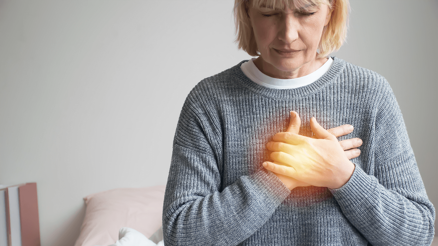 older woman experiencing heartburn symptoms with face scrunched up in pain