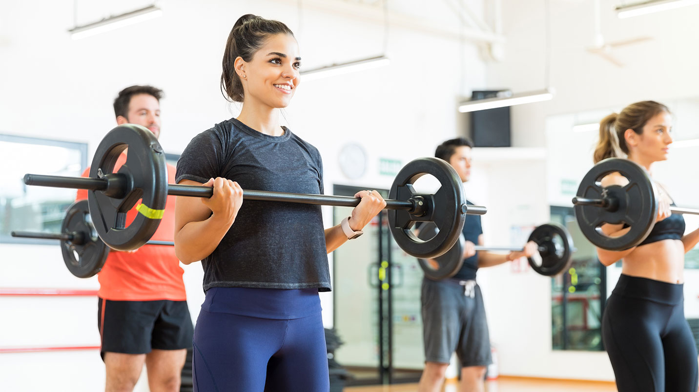 group of women and men lifting weights in a workout class