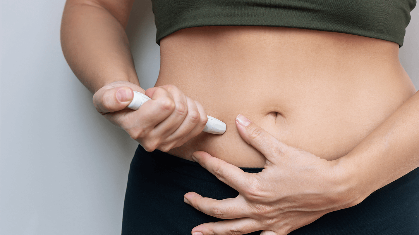 women injecting medication into her stomach