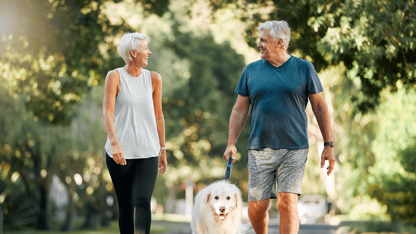 older couple on a walk wit their dog