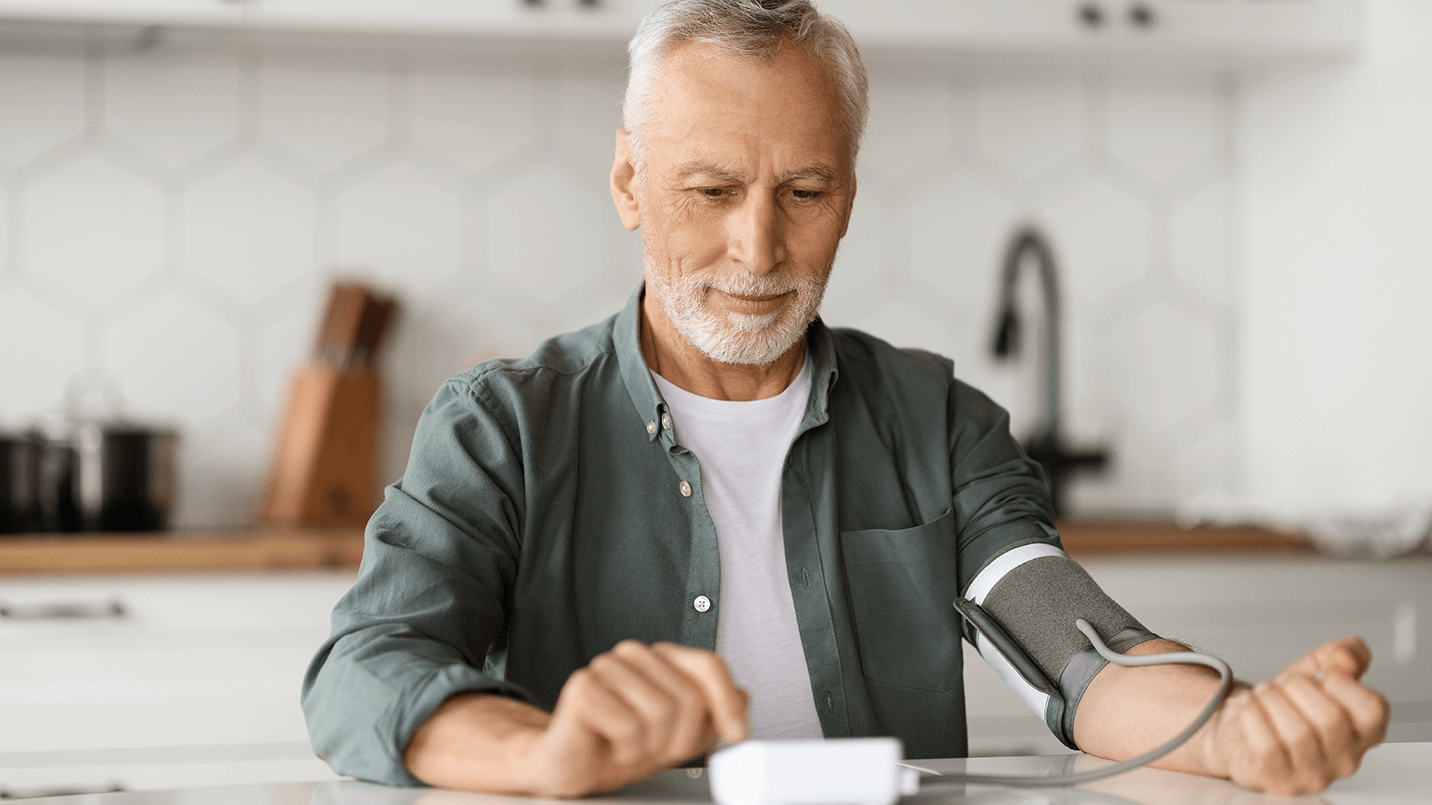 older man measuring his blood pressure at home