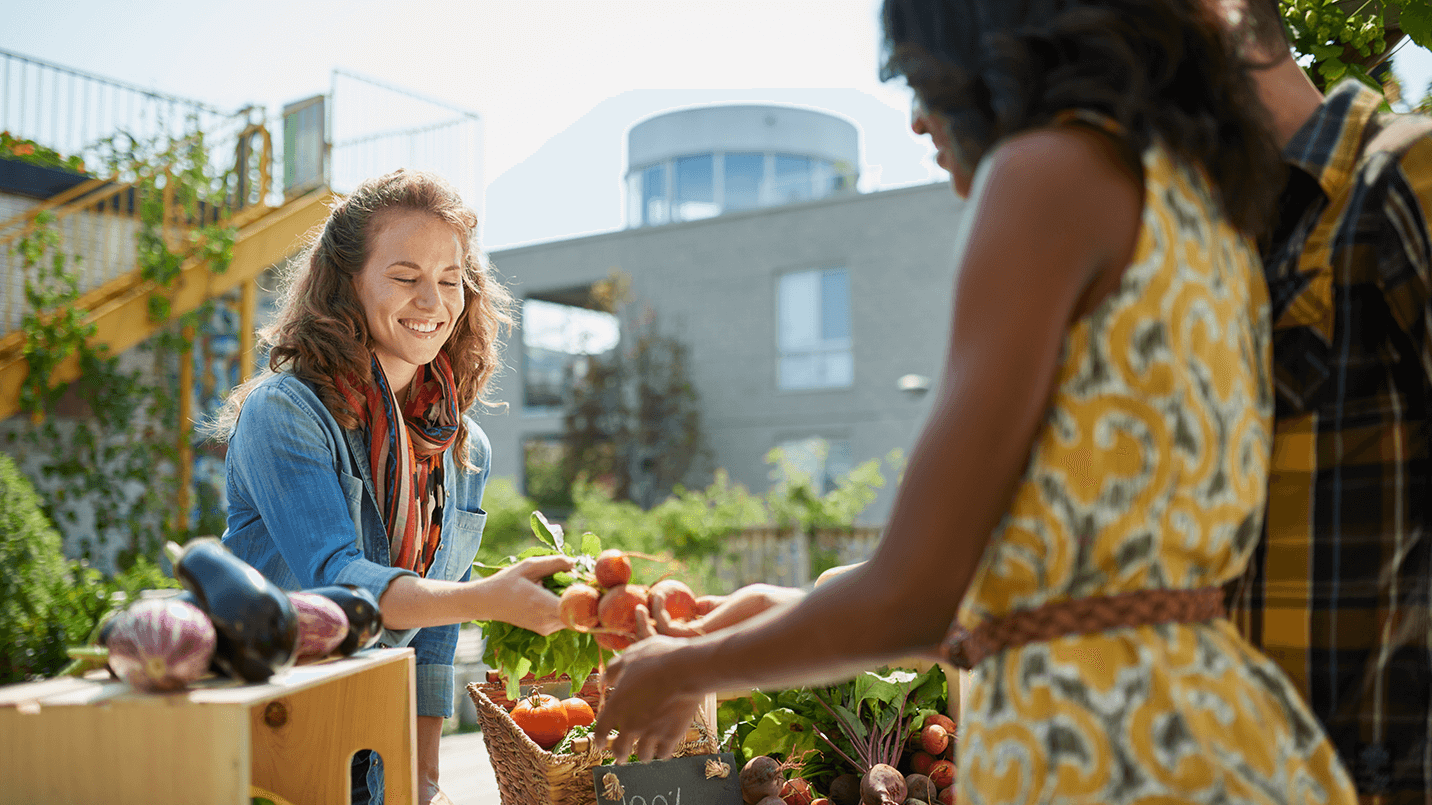 woman buying tomatoes at a farmers market