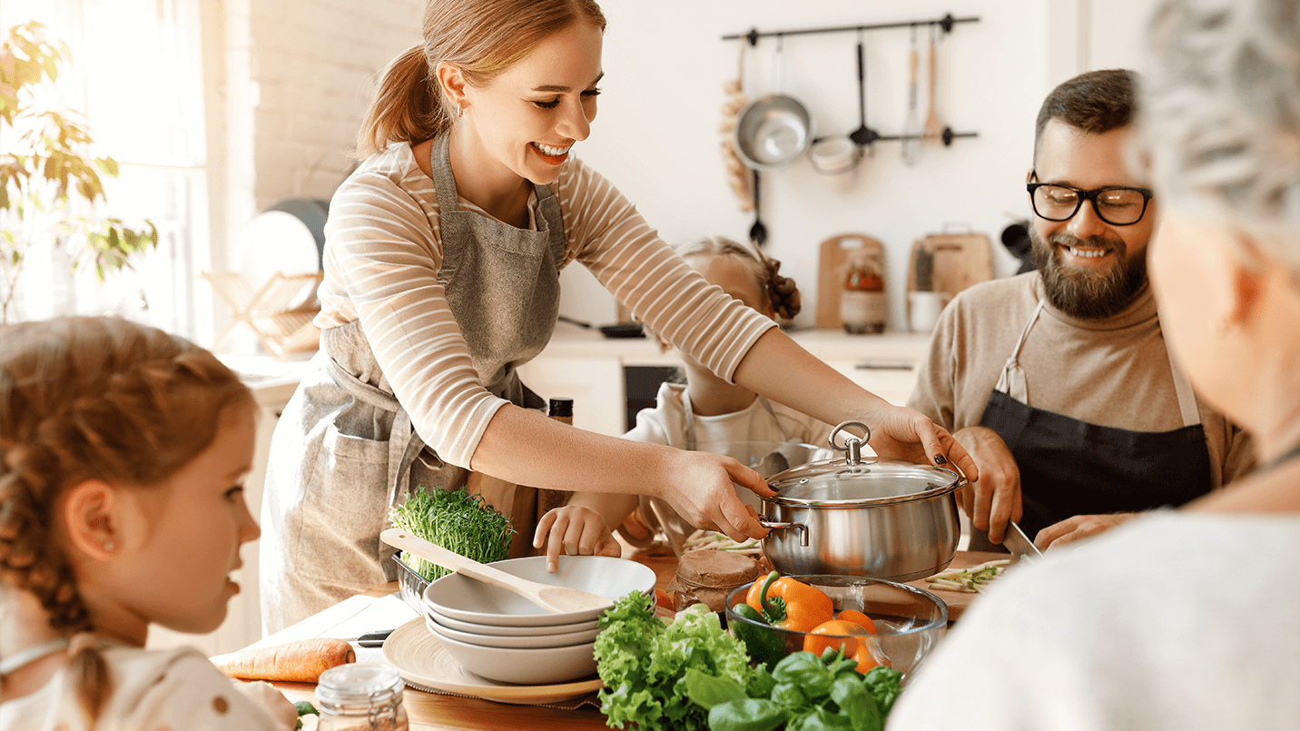 A family smiling and gathering to eat a healthy, nutrient-dense meal together