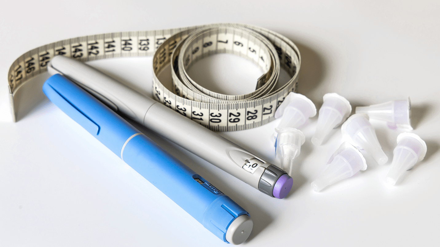 injectors pens, measuring tape and needle caps laying on counter