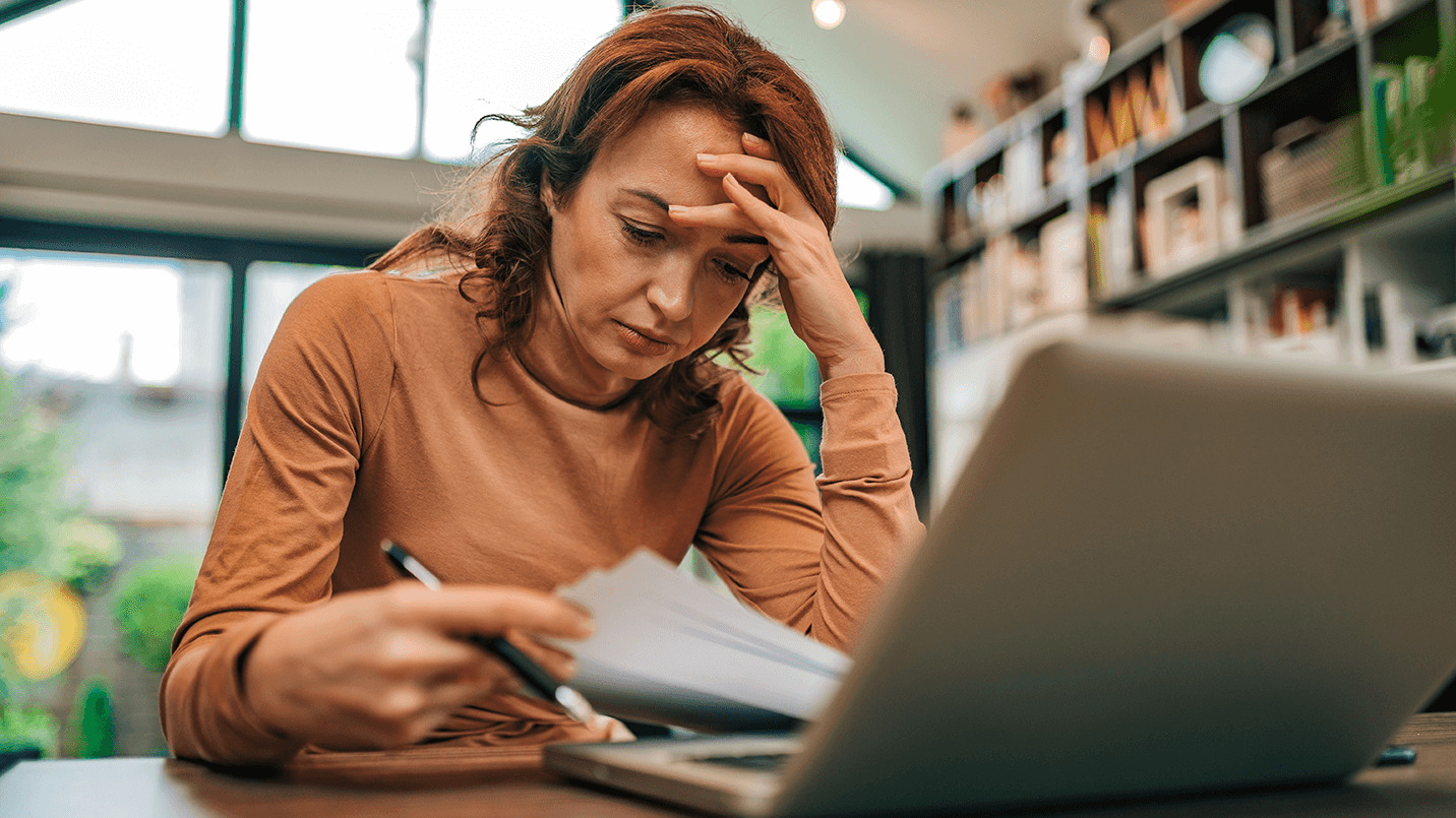 woman looking stressed while opening bills