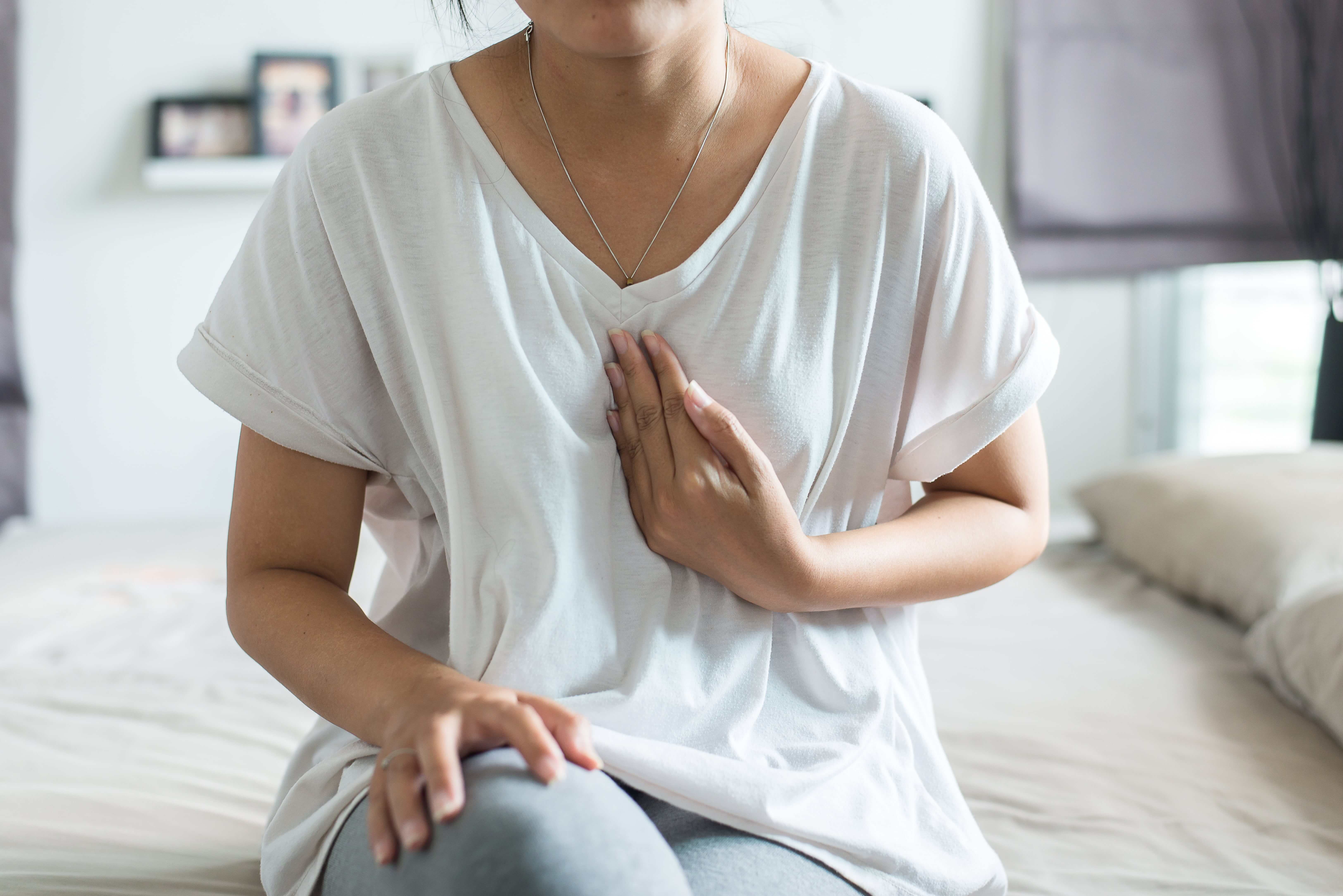 Woman touching her chest with heartburn pain. 