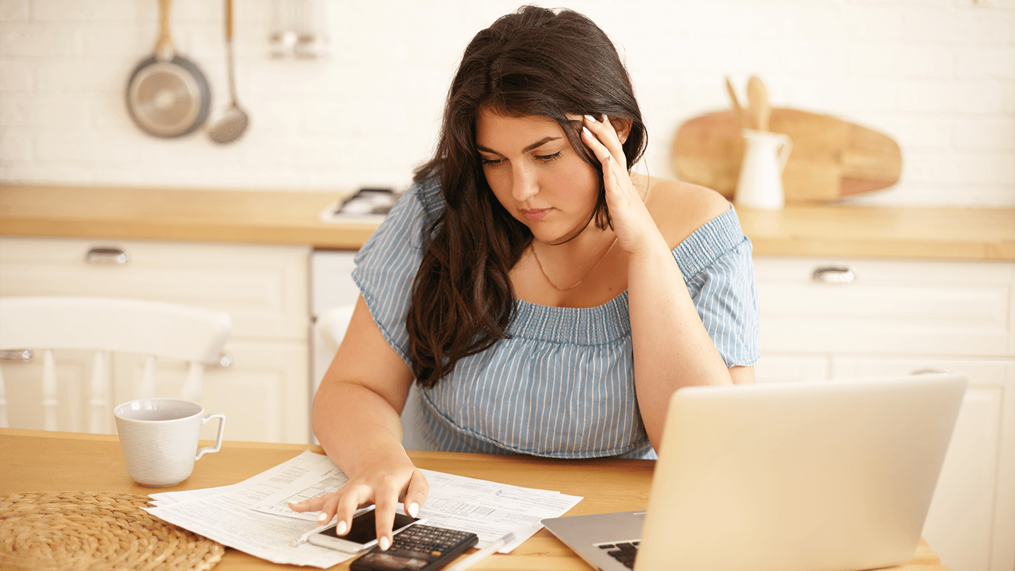 woman sitting at desk and looking stressed