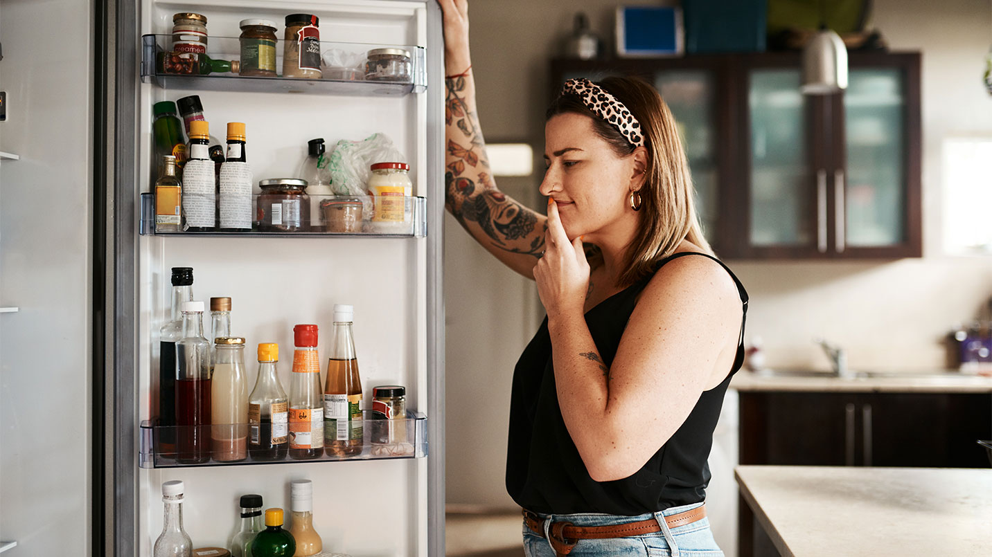 women looking in fridge to find something to eat