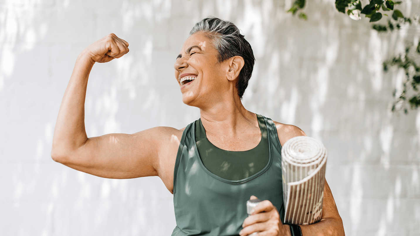 women flexing her right bicep and laughing