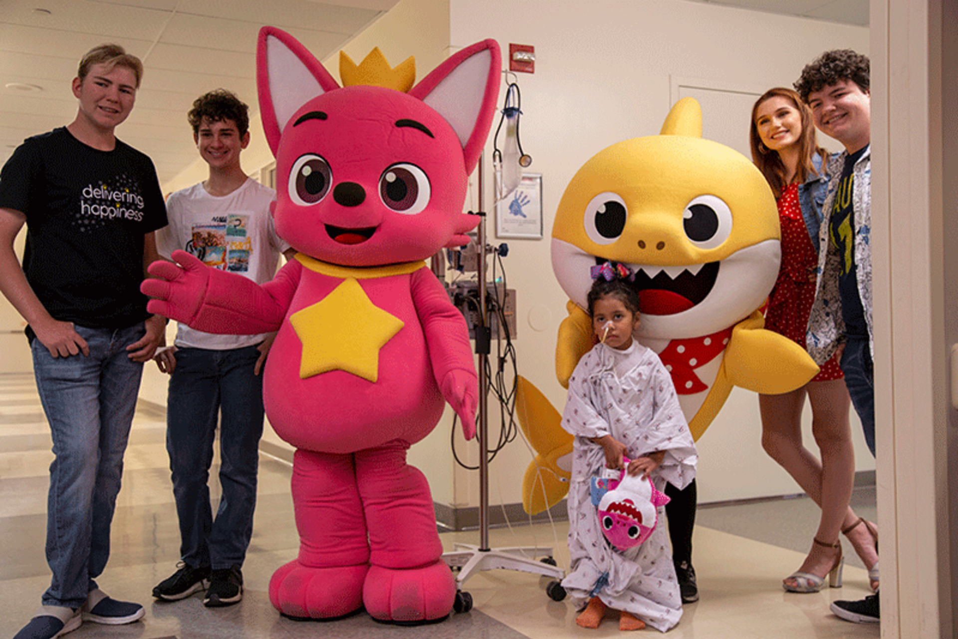 Kids in pediatric playroom posing with Baby Shark and Pinkfong 