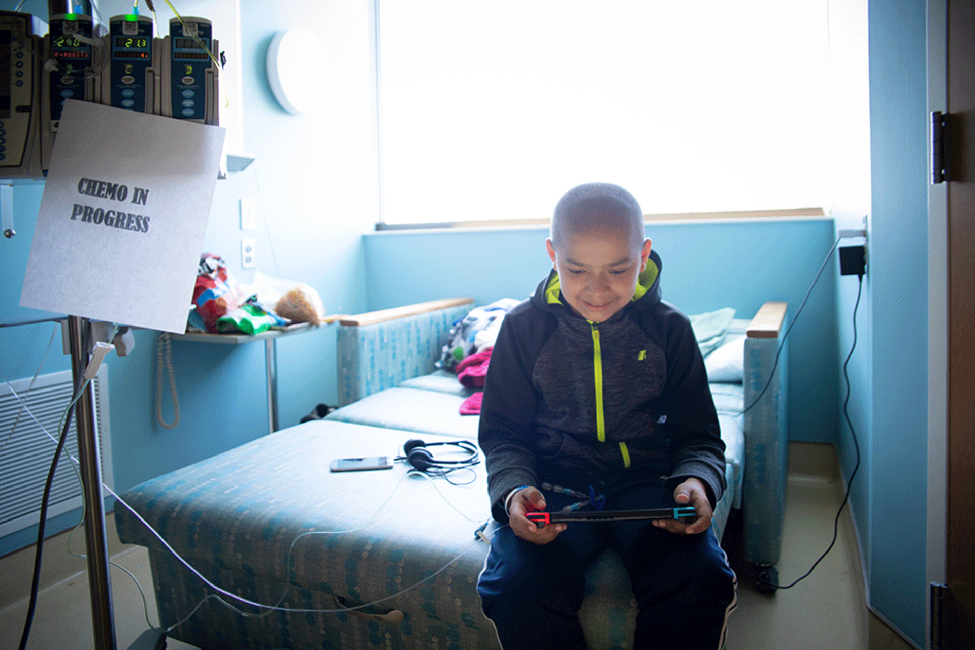 Boy playing with Starlight gaming undergoing chemo in hospital