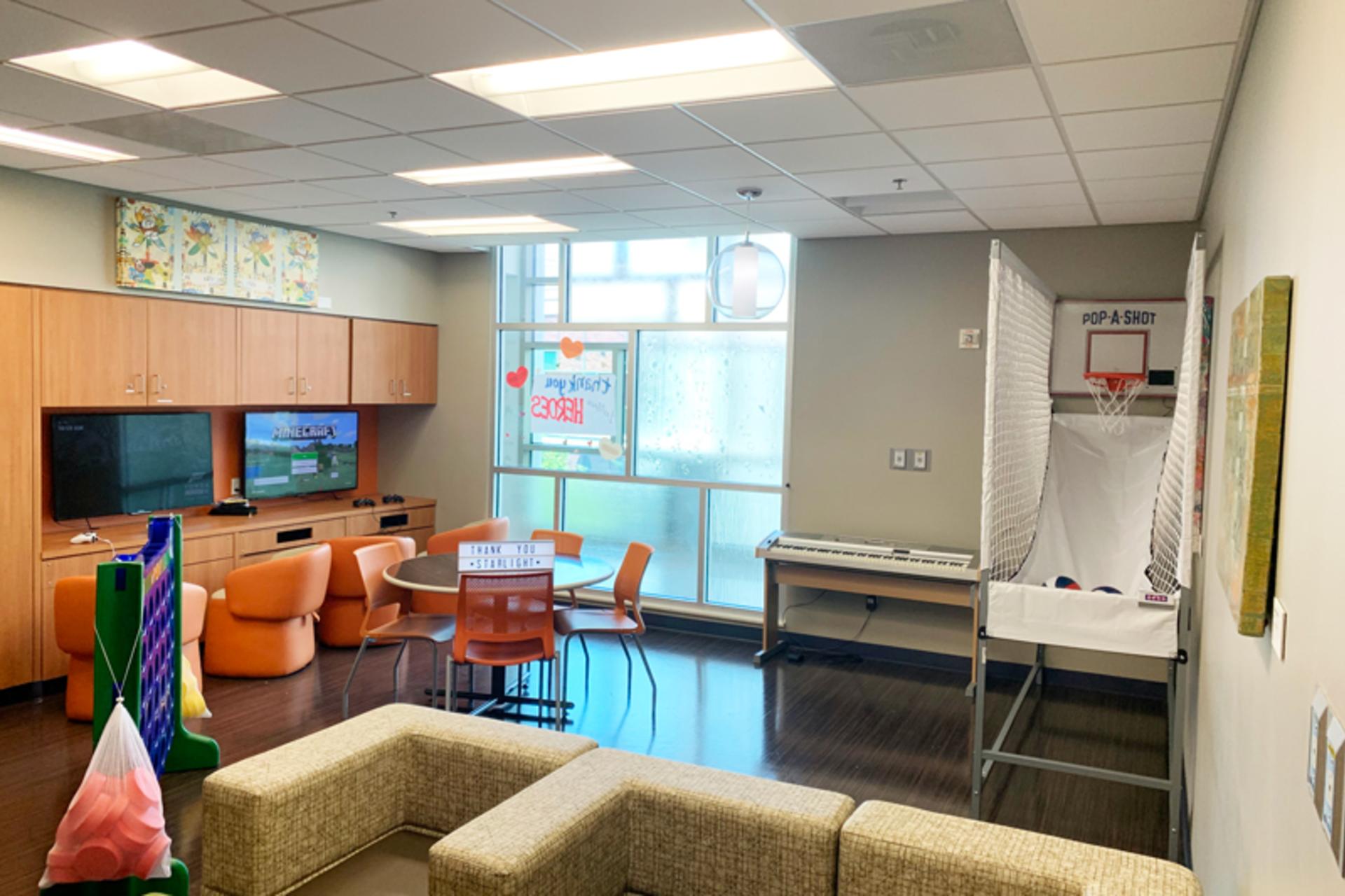 Updated Teen Room at Dell Children's Medical Center with basketball hoop game, couches, T.V.s and computers